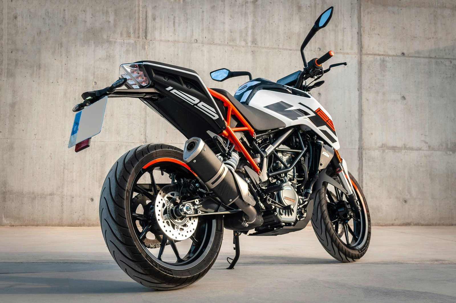 Sleek modern sports motorcycle parked on concrete background, showcasing its stylish design.